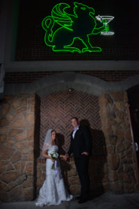 Photographers of Las Vegas - Wedding Photography - wedding bride and groom standing in front of Griffin neon sign