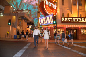 Photographers of Las Vegas - Wedding Photography - wedding couple at Fremont walking past the Vegas neon lights