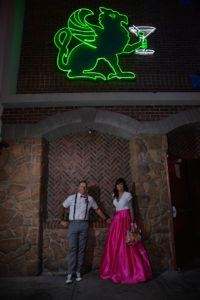 Photographers of Las Vegas - Wedding Photography - wedding bride and groom standing stone arch and green neon sign