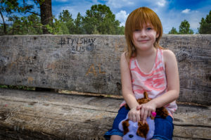 Photographers of Las Vegas - Portrait Photography - girl on wooden bench with carvings