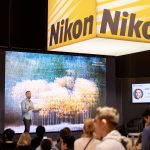 Photographers Of Las Vegas - Corporate Photography - Nikon presentation theater audience large screen cameras yellow black sign powerpoint