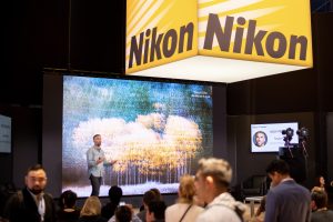 Photographers Of Las Vegas - Corporate Photography - Nikon presentation theater audience large screen cameras yellow black sign powerpoint