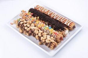 Photographers Of Las Vegas - Churros filled inside peanuts fruity pebbles Oreo drizzle toppings white plate