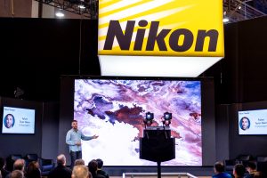 Photographers Of Las Vegas - Corporate Photography - Nikon presentation theater audience large screen cameras yellow black sign