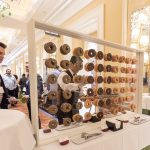 Photographers Of Las Vegas - Event Photography - Man with black blazer pattern button up convention donut wall