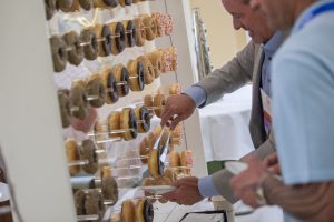 Photographers Of Las Vegas - Event Photography - Men with black blazer blue button up and blue polo. Man professional attire. Donut wall