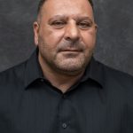 Photographers Of Las Vegas - Business Headshot Photography - Man with black button up. Man professional attire. Gray backdrop