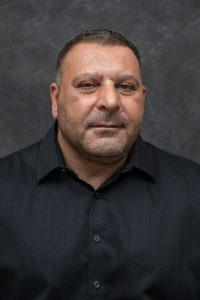 Photographers Of Las Vegas - Business Headshot Photography - Man with black button up. Man professional attire. Gray backdrop