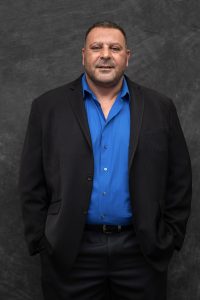 Photographers Of Las Vegas - Business Headshot Photography - Man with black blazer blue button up. Man professional attire. Gray backdrop
