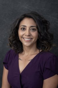 Photographers Of Las Vegas - Business Headshot Photography - Woman with grey texture background. Purple blouse. Woman professional attire. Short hair