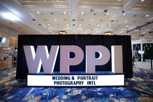 Photographers Of Las Vegas - Event Photography - WPPI convention big sign white letters blue rug