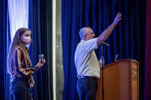 Photographers Of Las Vegas - Event Photography - South point stage blue drapery man speaking microphone woman holding box