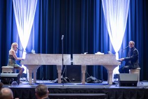 Photographers Of Las Vegas - Event Photography - Man woman playing piano singing preforming blue drapery