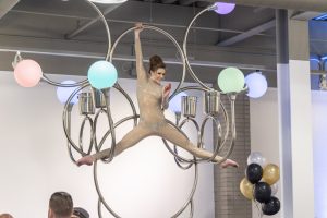Photographers Of Las Vegas - Event Photography - Woman preforming gold outfit hanging chandelier splits black white gold balloons
