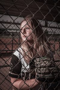 Photographers of Las Vegas - Senior photography - senior in softball uniform in dugout