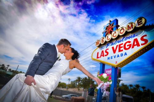 Photographers of Las Vegas - Vegas Strip Tour Photography - Groom dips the bride and they kiss at the iconic Vegas Sign